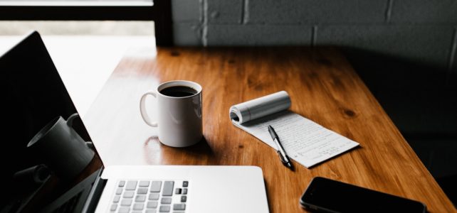 photo of computer, notepad and coffee mug