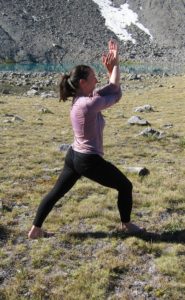 a person with arms in yoga eagle pose and legs in yoga Warrior I pose